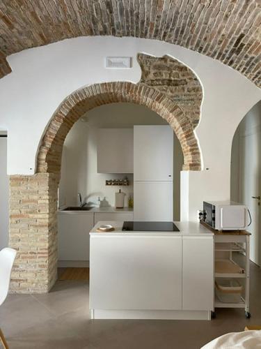 a kitchen with a brick archway and a white counter at Residenze Aimone in Vasto