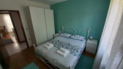 een slaapkamer met een bed in een kamer met groene muren bij Apartma Nona Roža in Zgornje Škofije