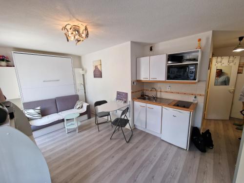 une cuisine et un salon avec un canapé et une table dans l'établissement Grand studio Front de mer ensoleillé avec jardin plein sud accès direct plage, à Cabourg