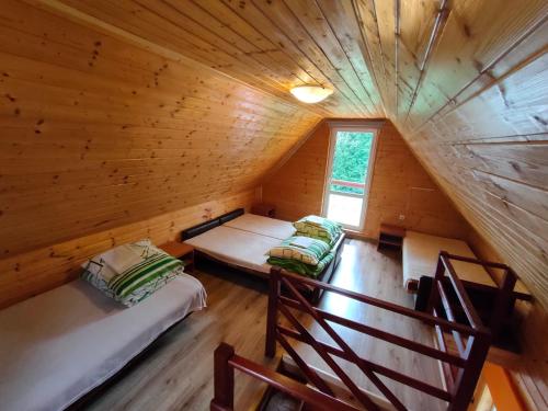 an attic room with two beds in a log cabin at Gospodarstwo Agroturystyczne na Górce in Myczkowce