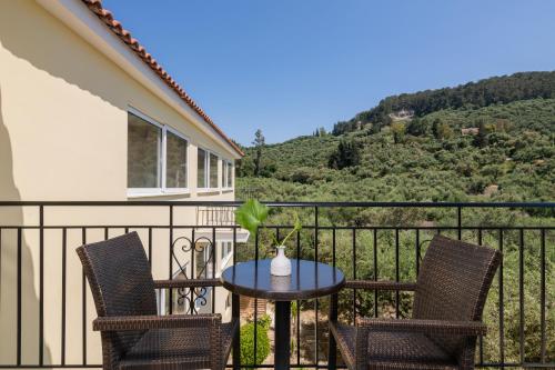 a patio with two chairs and a table on a balcony at Hotel Varres in Zakynthos Town