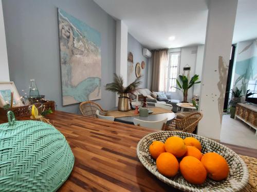 a living room with a bowl of oranges on a table at Hola Apartament Alicante in Alicante