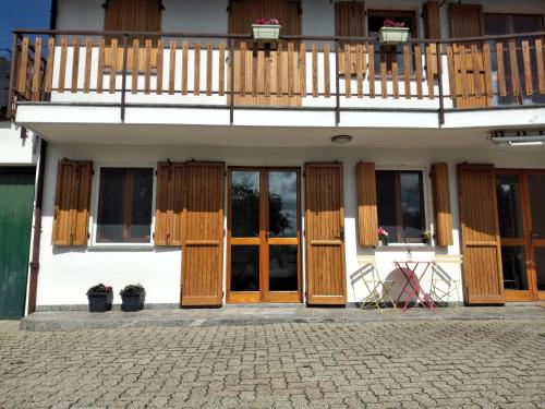 a building with wooden doors and a balcony at Appartamento a due passi da Burcina in Favaro