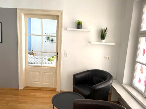 sala de estar con silla negra y ventana en Ferienapartment Passauer Wolf im Zentrum en Sankt Pölten