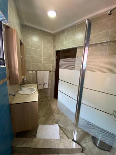 a bathroom with a shower and a sink at Bays Lodge, Accra in Accra