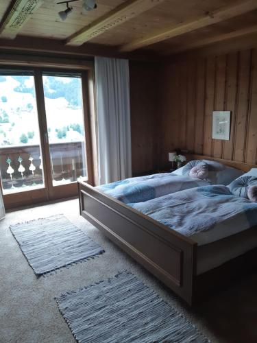- une chambre avec un grand lit en face d'une fenêtre dans l'établissement Ferienwohnung Schatzhof, à Jochberg