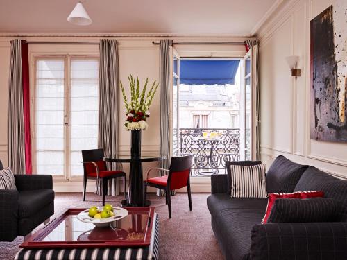 a living room with a couch and a table at La Tremoille Paris in Paris