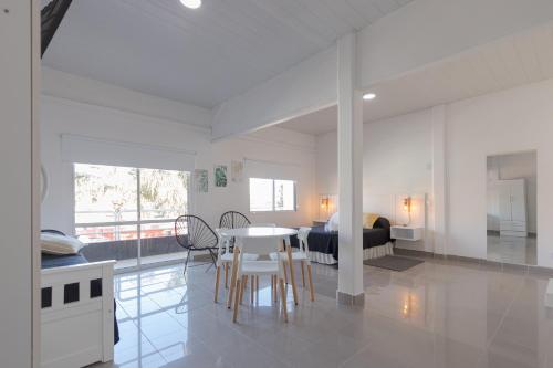 een witte kamer met een tafel en stoelen en een slaapkamer bij Hotel Crespo in Crespo