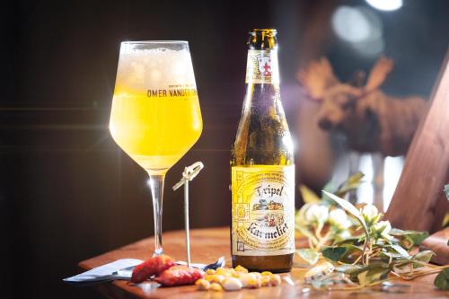 a bottle of beer sitting next to a glass at Långforsen Glamping & Lapland Experience in Haparanda