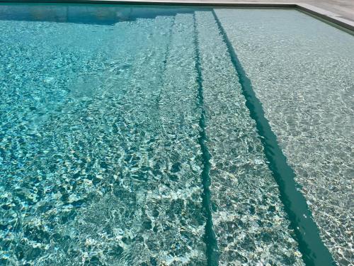 an overhead view of a swimming pool with blue water at Il Giardino Grande - Dimora in Salento in Parabita
