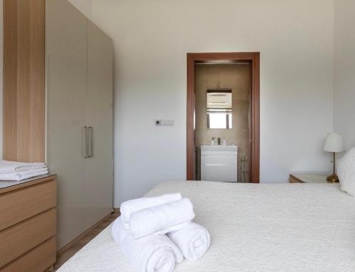 um quarto com uma cama com toalhas em SUNNY CAPTAINS HOUSE with a pool em Pendakomo