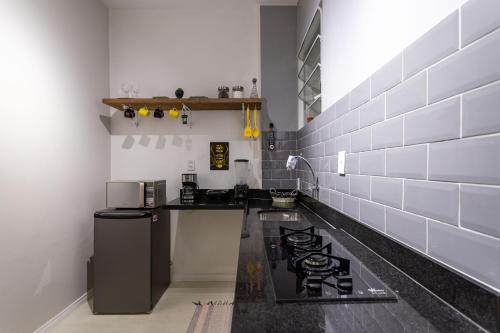 a kitchen with a counter and a stove in it at Studio em Botafogo- aconchegante e próximo ao shopping e ao metrô in Rio de Janeiro