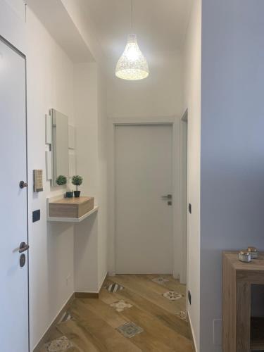 un couloir avec une porte, un miroir et une lampe dans l'établissement MIRAFIORI HOUSE, à Turin