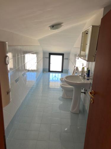 Baño blanco con 2 aseos y lavamanos en AREA 21 en Petacciato