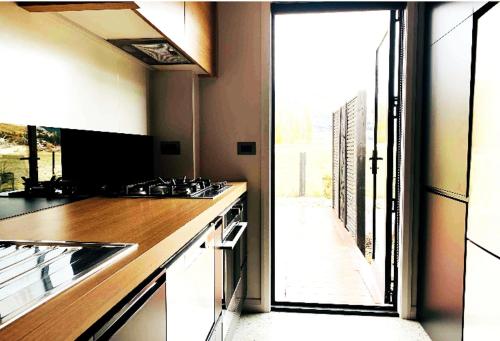 eine Küche mit einem Waschbecken und einem großen Fenster in der Unterkunft Orchard Lodge Wanaka - Relax, Refresh, Recharge in Wanaka
