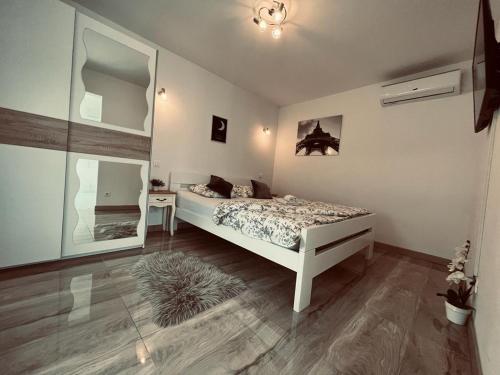 a bedroom with a bed and a table and a mirror at Apartman Bilivano in Zagreb