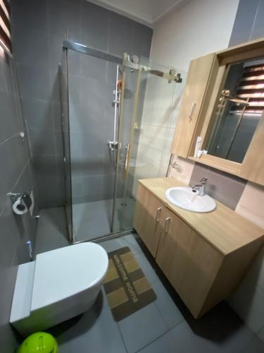 a bathroom with a shower and a toilet and a sink at Bays Lodge, Accra in Accra