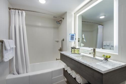 a bathroom with a tub, sink and mirror at InterContinental St. Paul Riverfront, an IHG Hotel in Saint Paul