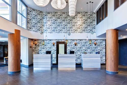 a lobby with a wall filled with pots at Sandman Signature Langley Hotel in Langley