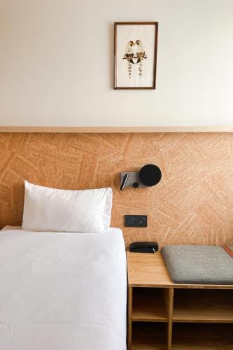 a bedroom with a bed and a table and a picture at Greet Hotel Colmar in Colmar