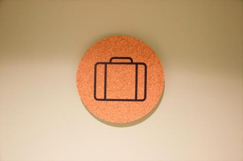 a red circle with a suitcase icon on a wall at Greet Hotel Colmar in Colmar