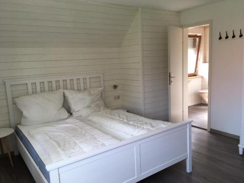 a white bed with white sheets and pillows in a room at Ferienwohnungen Rössle in Stiefenhofen