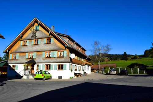 a large house with a car parked in front of it at Ferienwohnungen Rössle in Stiefenhofen