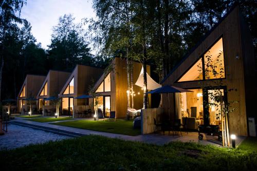 una casa con patio por la noche en Village Mielno - najpiękniejsze domki wakacyjne nad morzem en Mielno