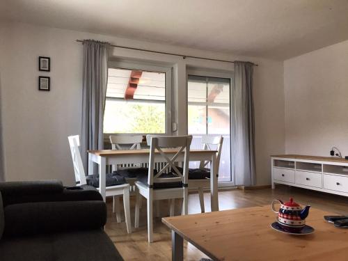 a living room with a table and a dining room at Ferienwohnungen Rössle in Stiefenhofen