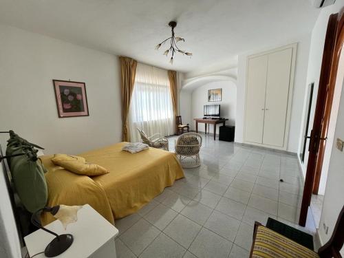 a bedroom with a bed with a yellow bedspread at Villa Loreta in Ischia