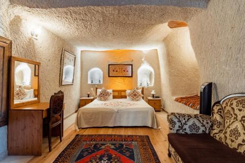 um quarto com uma cama e um sofá num quarto em Amber Cave Suites em Goreme