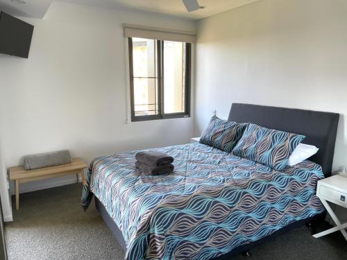 a bedroom with a bed and a window at Serenity Zealandia - Luxury 1brm unit at Darwin Waterfront in Darwin