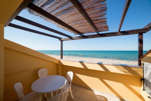 a balcony with a table and chairs and a view of the beach at Rex Residence Hotel in Cattolica