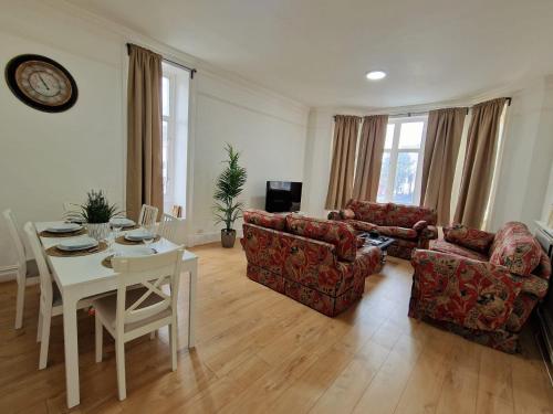un soggiorno con 2 divani e un tavolo e una sala da pranzo di Spacious 4 Bedroom apartment in amazing location a Londra