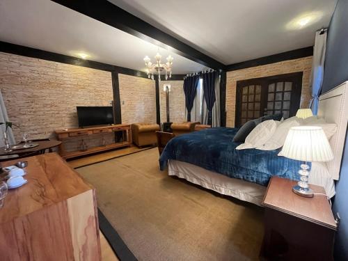 a bedroom with a bed and a flat screen tv at Pousada Dona Bendita in Monte Verde