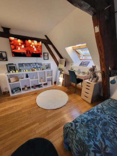 a attic room with a bed and a desk and a room at Gîte au cœur des vignes avec piscine et spa in Saudoy
