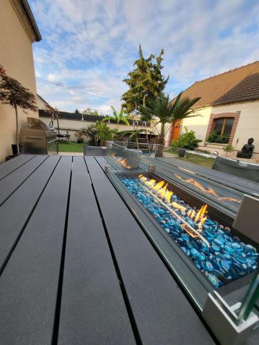 a patio with a fire pit in a yard at Gîte au cœur des vignes avec piscine et spa in Saudoy