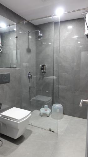 a bathroom with a toilet and a glass shower at Annandam Inn(Hotel Anand) in Seonī