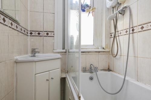 ein Badezimmer mit einer Dusche, einer Badewanne und einem Waschbecken in der Unterkunft Ealing Hububb Stay in Ealing