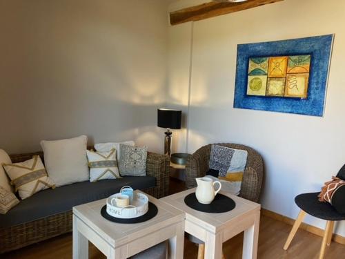 een woonkamer met een bank en 2 tafels bij Le moulin Bertrand in Martigny-Courpierre