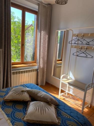 a bedroom with a bed with two pillows and a window at Le moulin Bertrand in Martigny-Courpierre