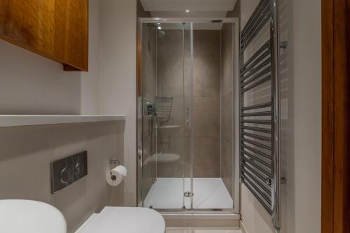 a shower with a glass door in a bathroom at Studio - Tower Hill - City Centre by Prime London Stays N-5 in London