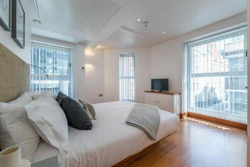 a bedroom with a large white bed and large windows at Studio - Tower Hill - City Centre by Prime London Stays N-5 in London