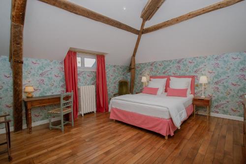 a bedroom with a bed and a wooden floor at Domaine du Chateau Vert in Hondainville