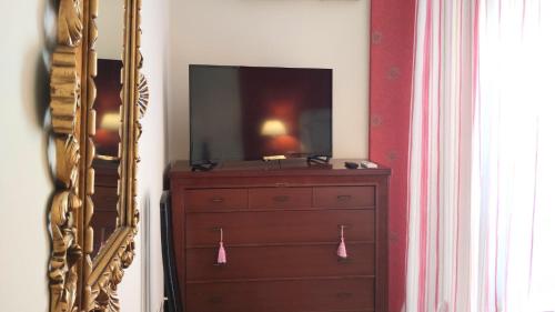a dresser with a television on top of it next to a mirror at Villa Granada Motril in Motril