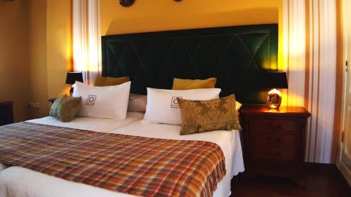 a bedroom with a bed with a large headboard and pillows at Villa Granada Motril in Motril