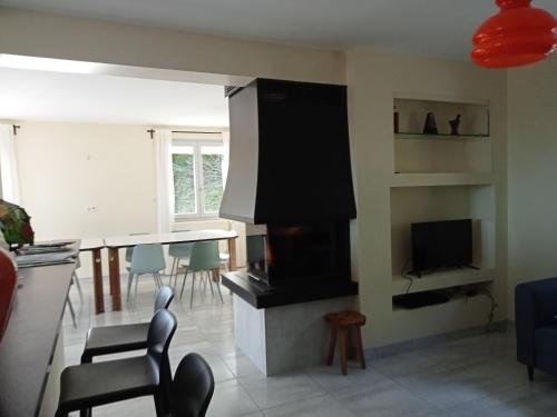 a living room with a fireplace and a table with chairs at Vaste villa en position dominante superbe vue lacs in Hautecour