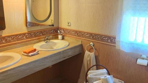 a bathroom with two sinks and a mirror at Villa Granada Motril in Motril