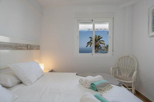 Shore Thing Playa في لا هيرادورا: غرفة نوم بيضاء بها سرير ونافذة