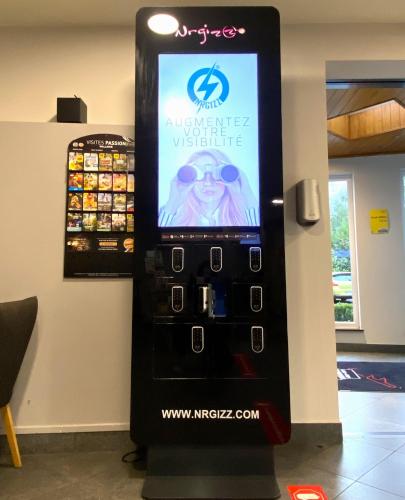 a vending machine with a sign on the side of a wall at Ibis Styles Charleroi Airport Aero 44 in Charleroi